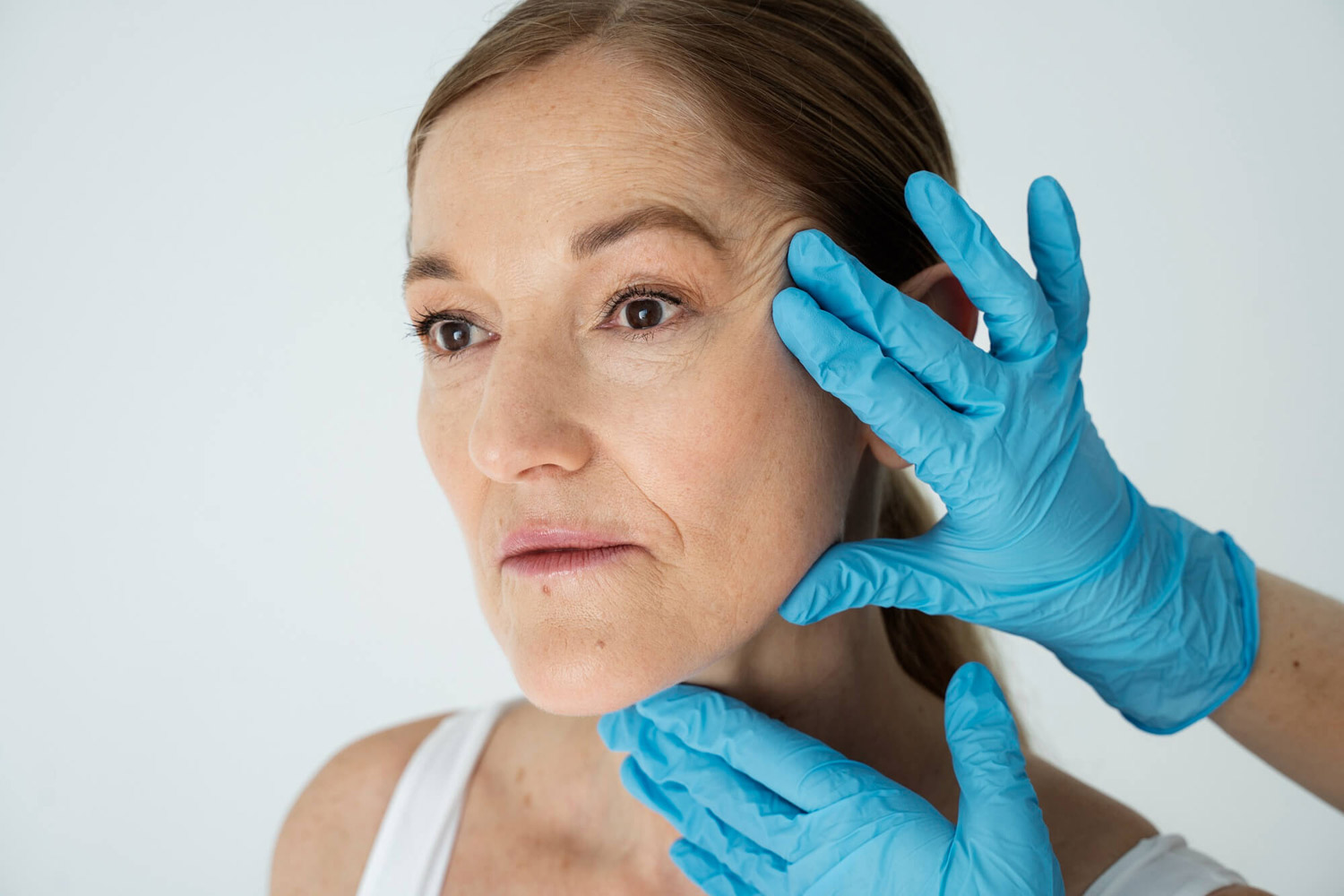 Fisioterapeuta masajea el rostro de una mujer con parálisis facial