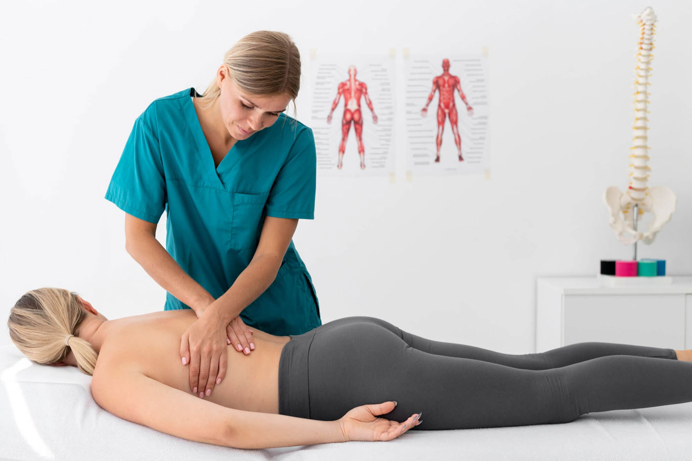Fisioterapeuta aplica un masaje en la zona lumbar de una paciente con ciática.
